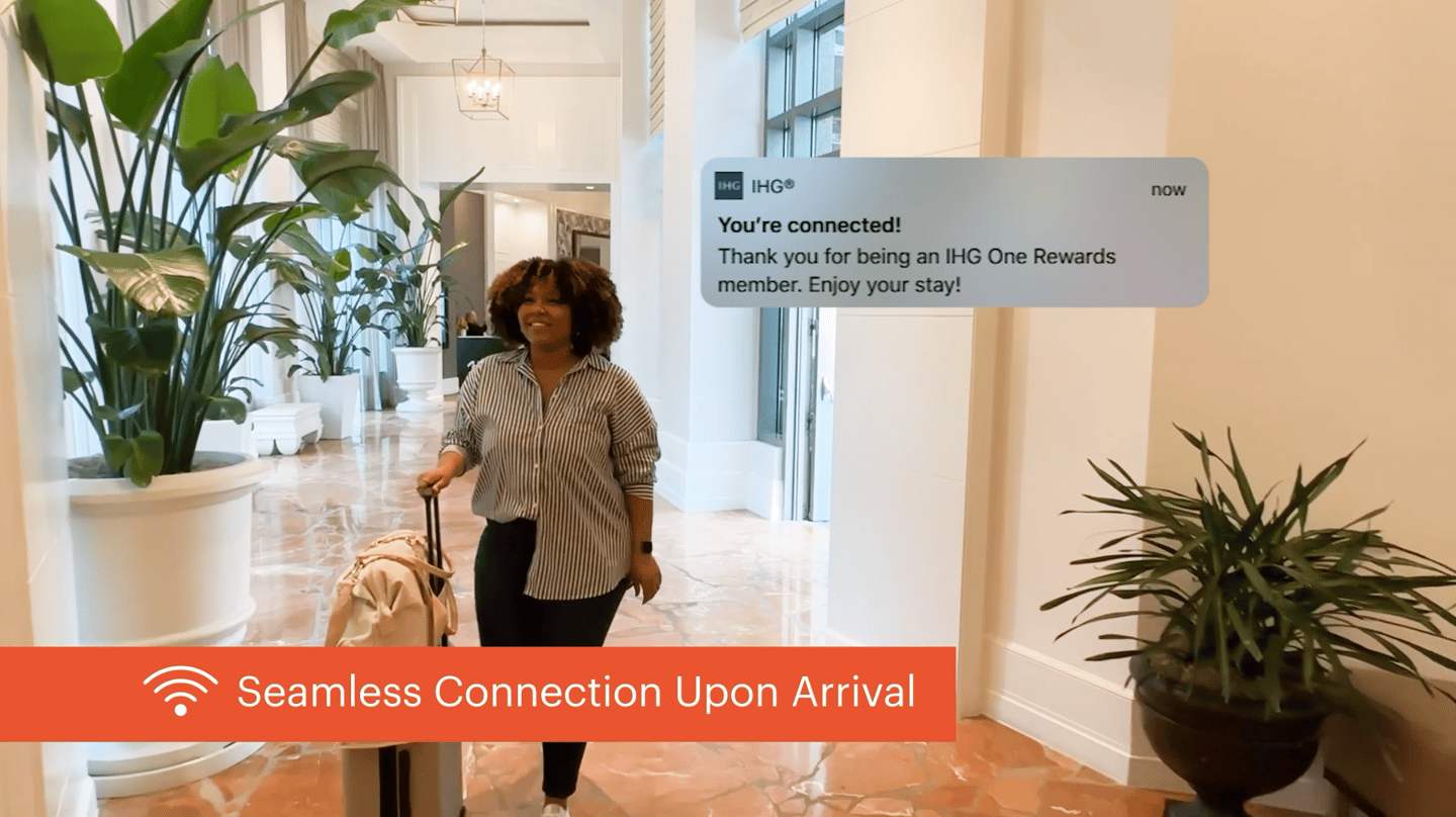 woman in hotel lobby gets wifi auto connect notification on smartphone