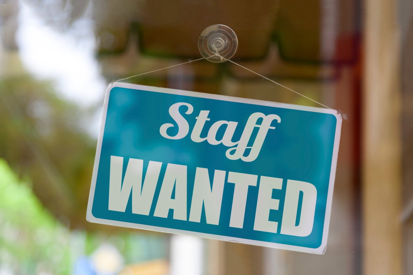 Close-up on a blue open sign in the window of a shop displaying the message: Staff wanted.; Shutterstock ID 1760558399