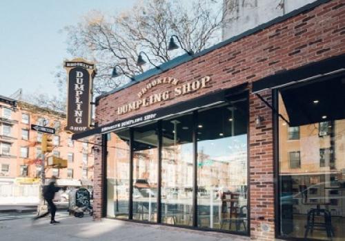 a large brick building with a store on a city street