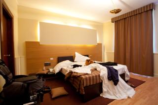 a bedroom with a bed and desk in a hotel room