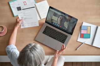 a group of people sitting at a table with a laptop
