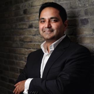 Alexander Mirza wearing a suit and tie