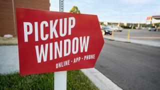 Noodles drive-thru pickup window this way sign.
