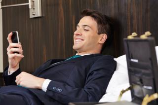 a man sitting in a chair talking on a cell phone
