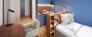 a bedroom with a bed and desk in a room