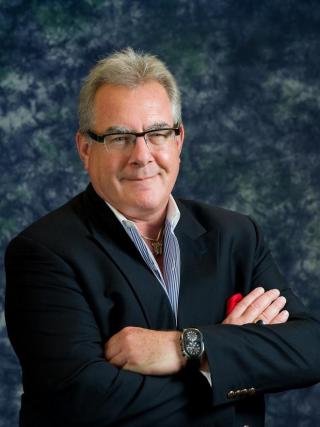 a man wearing glasses and looking at the camera