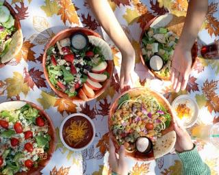a group of people sitting at a table with a plate of food