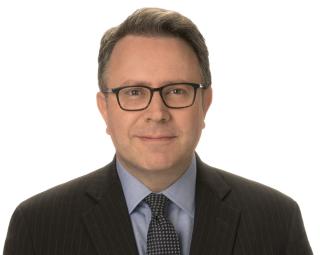 a man wearing glasses posing for the camera
