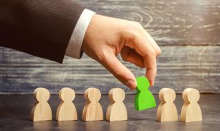 wooden people one green to indicate hiring