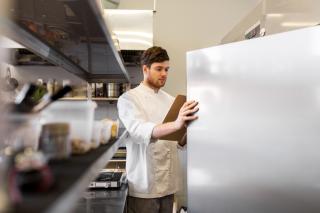 a person standing in front of a refrigerator with inventory checklist