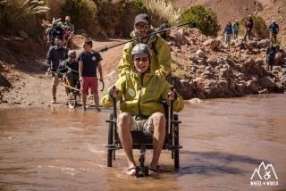 Wheelchair-bound persons on a hike, near a lake