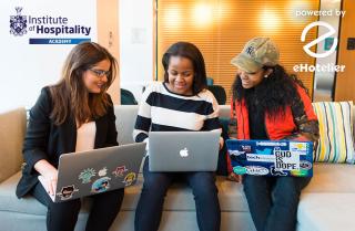a group of people looking at multiple laptops