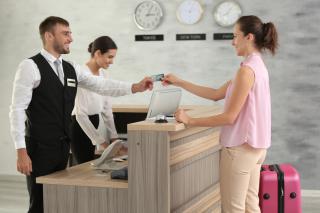Hotel employee accepting credit card for payment from guest