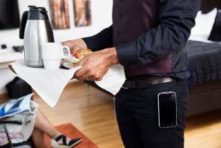 person standing with a phone clipped to his belt