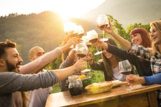a group of people standing around a table with food