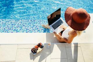 woman using laptop by the pool
