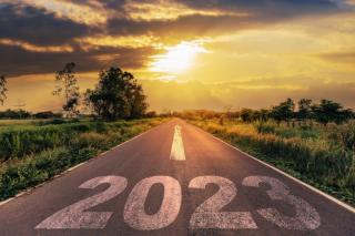 a 2023 sign in front of a sunset