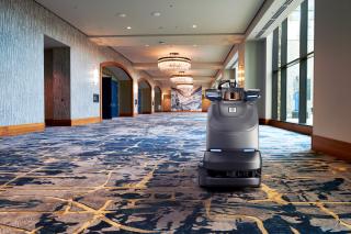 Brain Corp. robotic vacuum in hotel ballroom