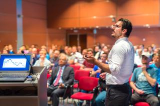 person standing up at event using microphone