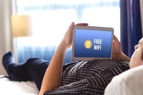 a person lying on a bed using a laptop