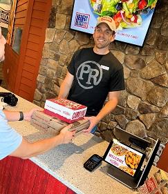 man at counter Revel pizza