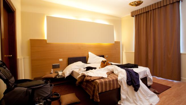 a bedroom with a bed and desk in a hotel room
