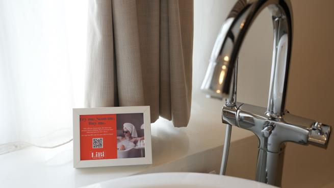 Tub filled with water w/ QR code next to it advertising spa products are for sale