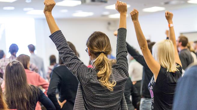 women standing up with hands in the air
