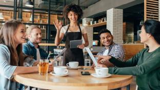 server with tablet and happy diners